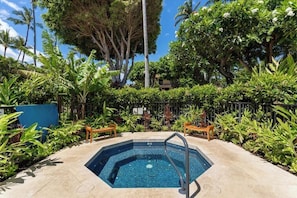 A swimming pool surrounded by lush greenery and palm trees, with a clear blue sky above. - Fully Remodeled Oceanfront Condo MAKENA SURF RESORT, #F-206 (Makena, Maui)