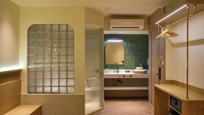 A bathroom with a wooden bench, a glass shower enclosure, a sink with a towel rack, and a mirror. - Aizen Stay - District 1 (Ho Chi Minh City)