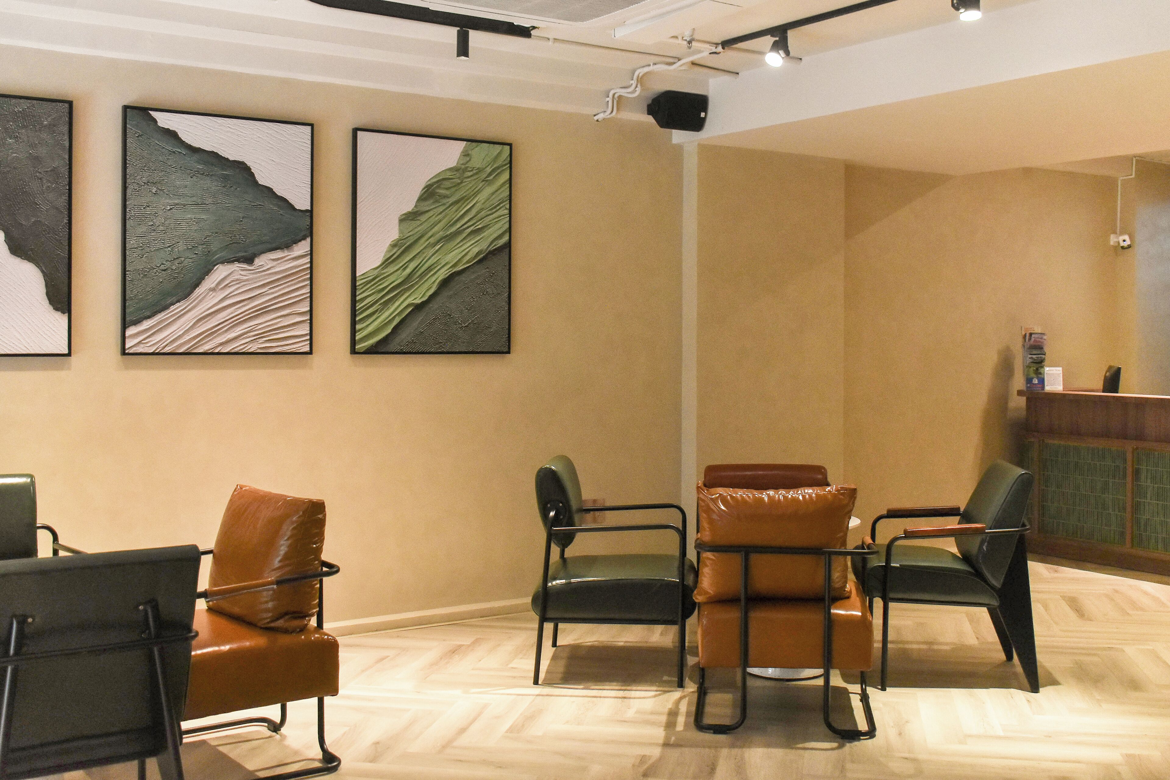 A conference room with a high ceiling, a white ceiling light, and a reception desk with a green tiled counter.