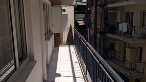 A narrow balcony with a tiled floor, a metal railing, and a view of adjacent buildings. - Anka 1 (Aydın)