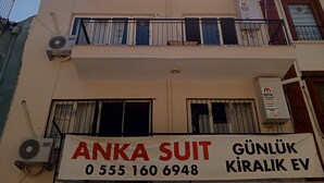 A multi-story building with balconies, air conditioning units, and a signboard for 'ANKA SUIT' with contact information. - Anka 1 (Aydın)