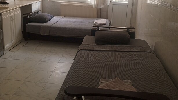 A compact room with two single beds, a small kitchenette, and a window providing natural light. - Anka 1 (Aydın)