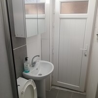 A bathroom with a toilet, sink, and a door.