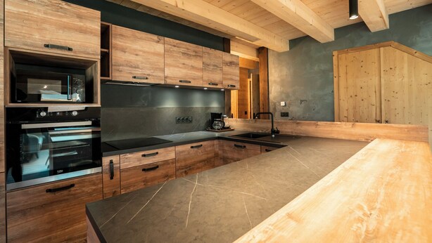 A modern kitchen with wooden cabinets, a large island, and built-in appliances. - Large Duplex for 10 People At the Base of the Slopes & Bike Park • Garage & View (Châtel)