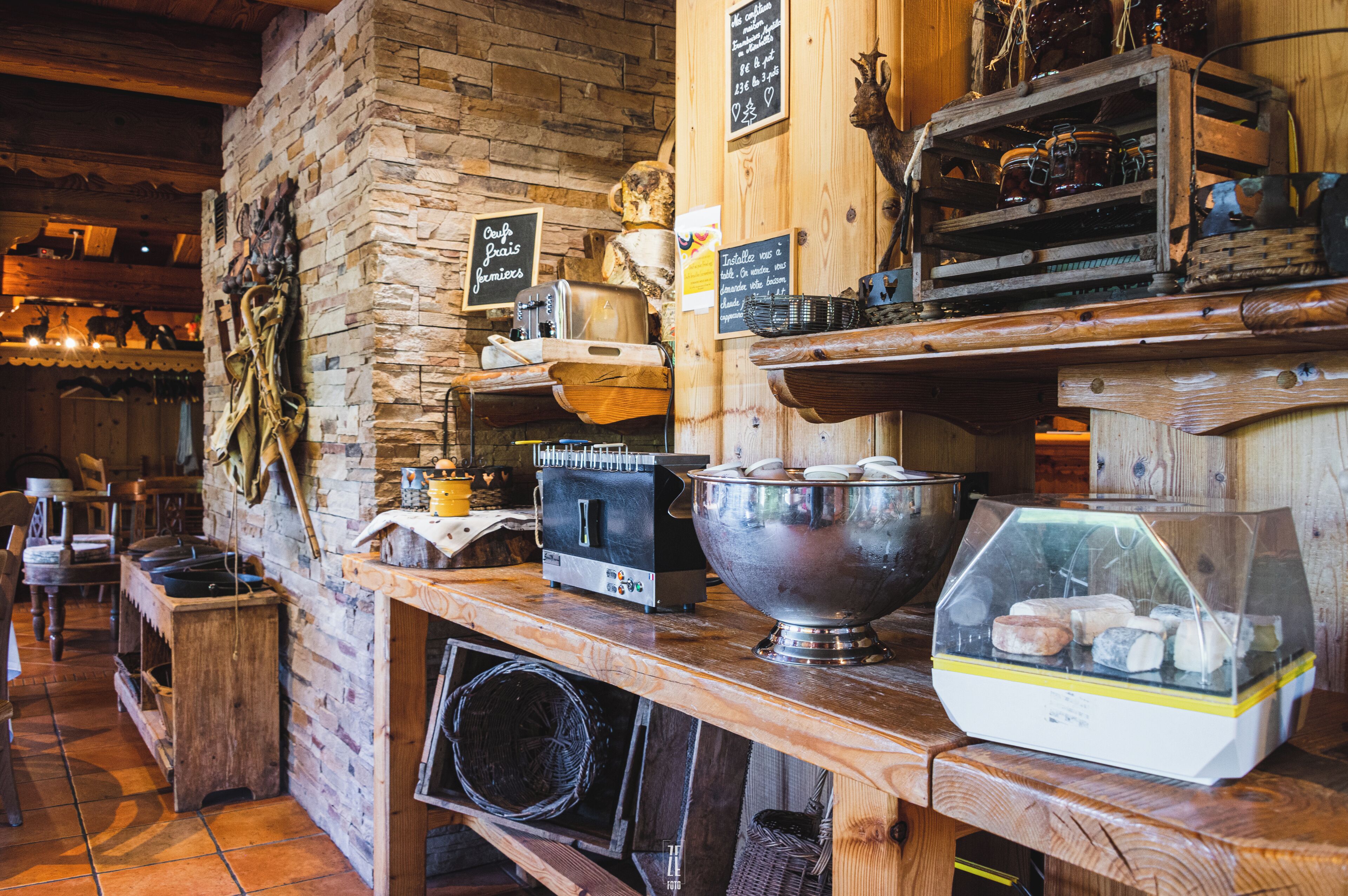 Un interior rústico con paredes de piedra, muebles de madera y diversos electrodomésticos de cocina.
