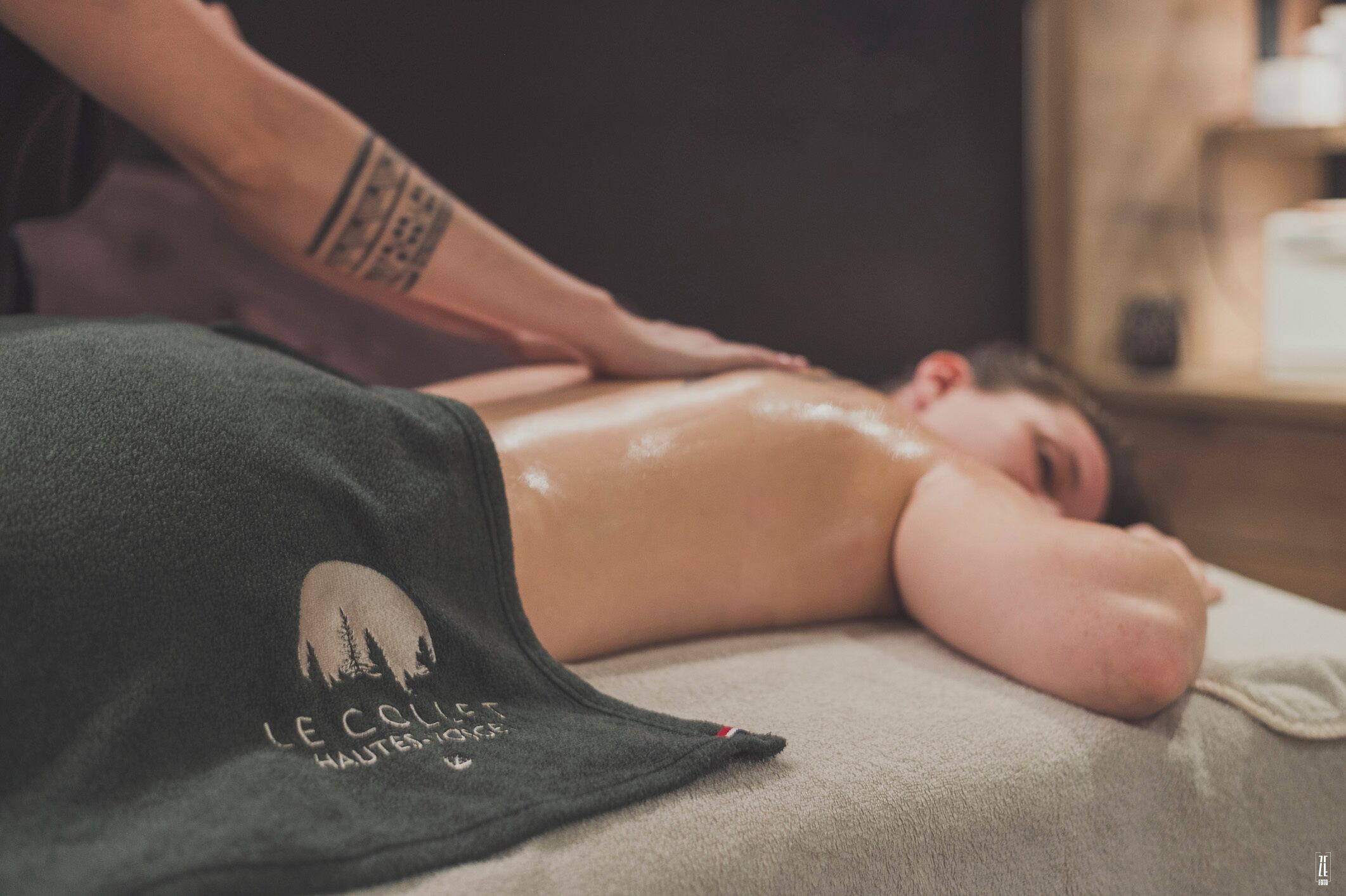A person receiving a massage in a room with a massage table and a towel.