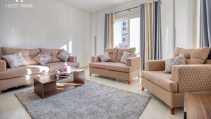 A modern living room with beige sofas, a wooden coffee table, and a grey rug.