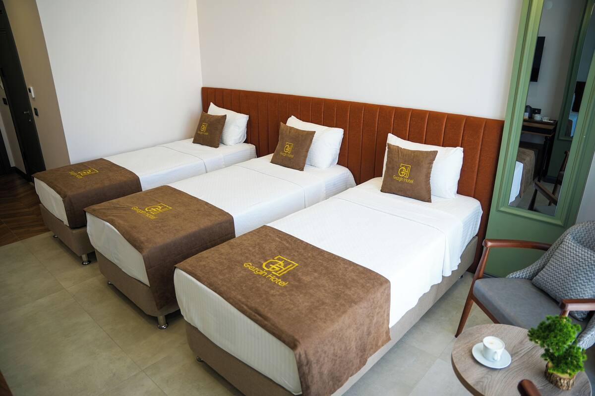 Deluxe Triple Room, City View | In-room safe, desk, laptop workspace, blackout drapes