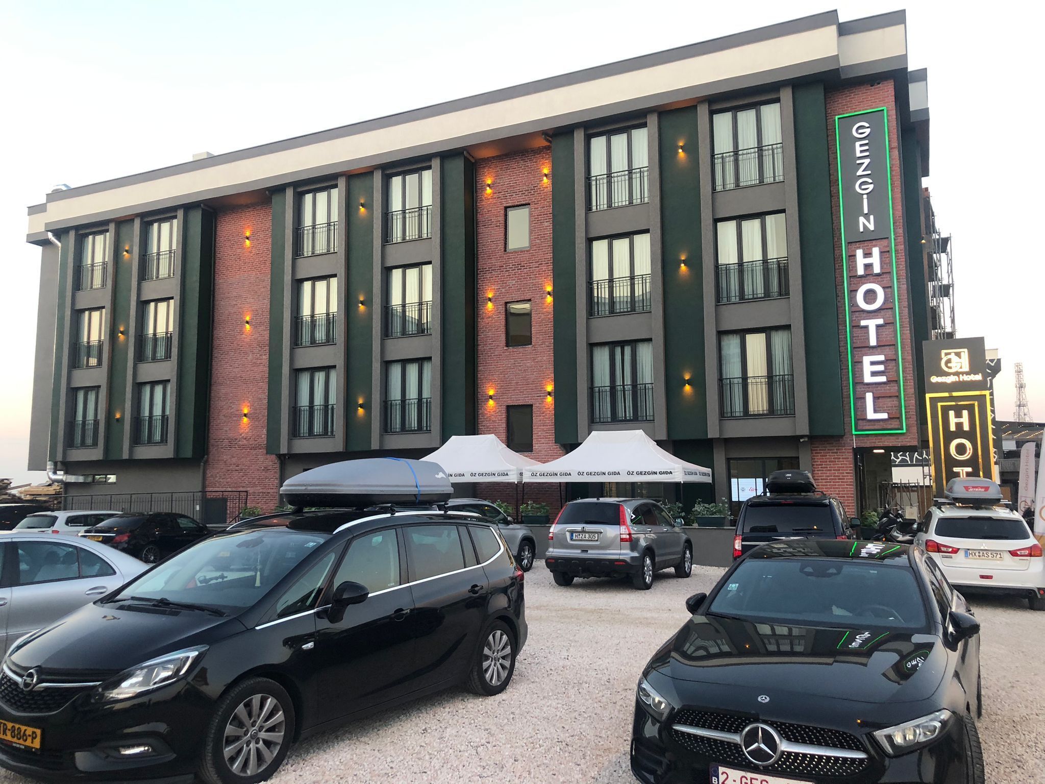 Un edificio de hotel con varios pisos, ventanas amplias y un cartel llamativo.