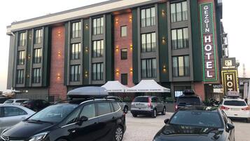 Un edificio de hotel con varios pisos, ventanas amplias y un cartel llamativo.