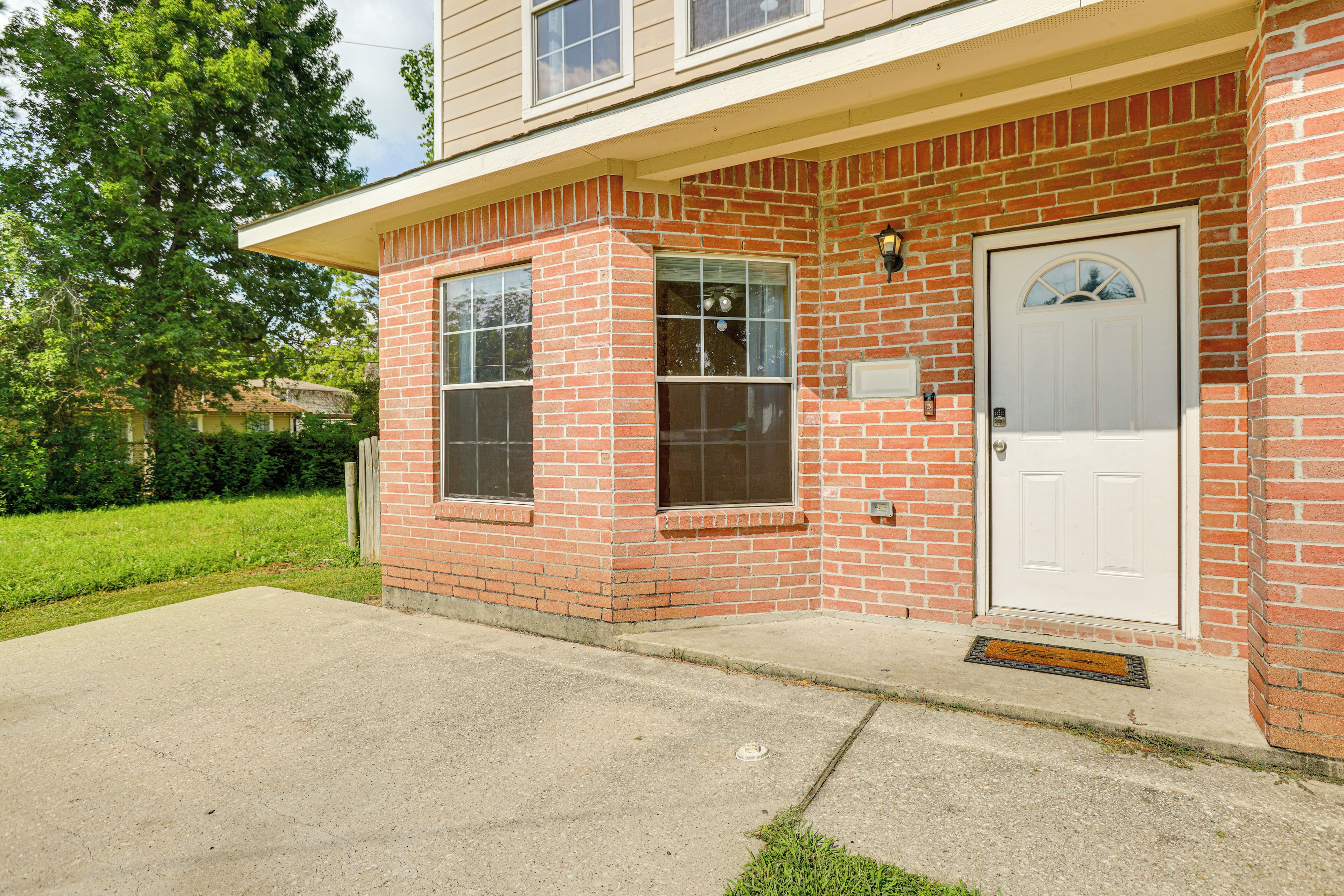 A two-story brick house with a front porch, a white door, and a mailbox.