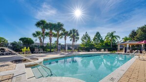A swimming pool with lounge chairs and palm trees. - Resort Amenities, Screened Lanai: Kissimmee Escape (Kissimmee)