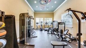 A gym with various exercise equipment, including weight machines and free weights, and a bench. - Resort Amenities, Screened Lanai: Kissimmee Escape (Kissimmee)