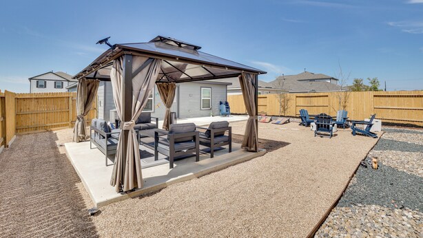 A covered patio area with seating and a pergola. - Game Room + Private Yard: Modern San Antonio Home (San Antonio)