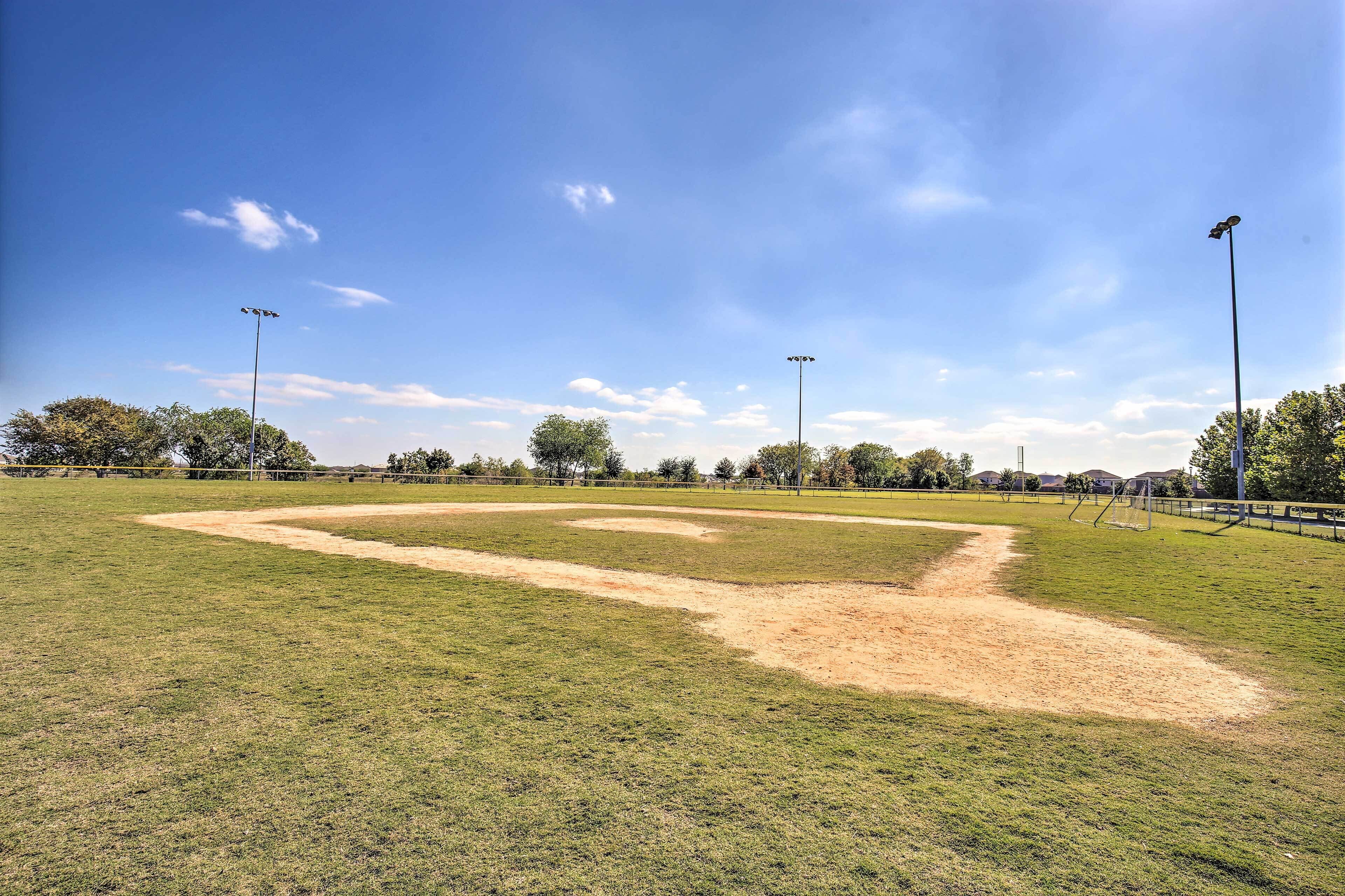 A baseball field with clear skies and a dirt infield.
