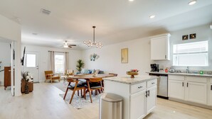 A modern kitchen with white cabinets, a granite countertop, and a built-in dishwasher. - Game Room + Private Yard: Modern San Antonio Home (San Antonio)