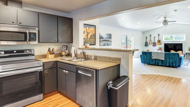 A modern kitchen with stainless steel appliances, a granite countertop, and a wooden floor. - Close to Everything! Quiet Retreat in Bend (Bend)