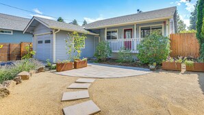 A residential house with a front porch, a garage, and a landscaped garden with stepping stones leading to the entrance. - Close to Everything! Quiet Retreat in Bend (Bend)