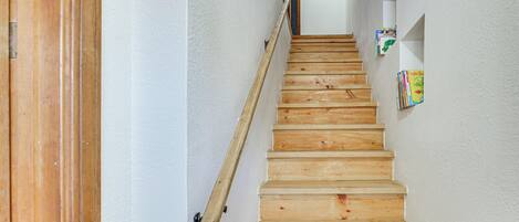 Una escalera de madera con barandilla que lleva a una plataforma.