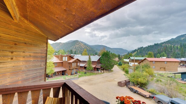 Un bâtiment en bois doté d’un balcon donnant sur un village et des montagnes.