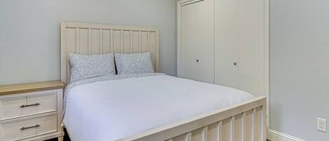 Ein Schlafzimmer mit Bett, Nachttisch, Kleiderschrank und Holzboden.