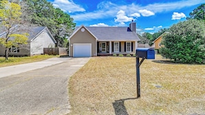 A single-story house with a front porch, a garage, and a mailbox. - Large Yard, Office Space: Fayetteville Family Home (Fayetteville)
