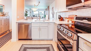 A modern kitchen with a dishwasher, stove, and oven.