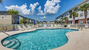 A swimming pool with lounge chairs and a 3 ft diving board.