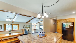 A kitchen with granite countertops, wooden cabinets, a black refrigerator, and a dining area with a wooden table and chairs. - 'hayward Valley House' Black Hills Family Retreat (Keystone)