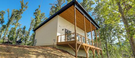 A two-story house with a wooden deck and a covered porch.