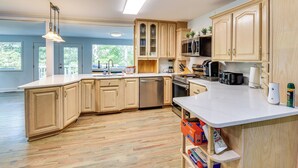 A spacious kitchen with wooden cabinets, a large island, and modern appliances.
