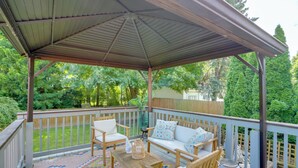 A covered patio with wooden furniture, a patterned rug, and a view of a backyard. - Steps to Lake Erie! Cedar Point Home Base w/ Deck (Sandusky)