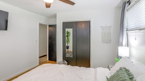 A bedroom with a ceiling fan, a bed with white bedding, a bedside lamp, a mirror, and a potted plant. - Steps to Lake Erie! Cedar Point Home Base w/ Deck (Sandusky)
