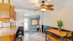 A kitchen with wooden cabinets, a bar area, and a dining table with benches. - Steps to Lake Erie! Cedar Point Home Base w/ Deck (Sandusky)