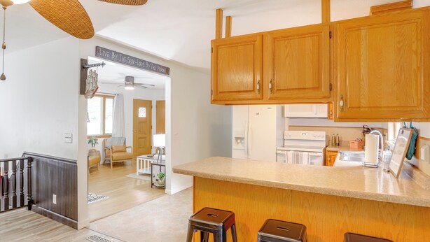 A kitchen with wooden cabinets, a countertop, and two stools. - Steps to Lake Erie! Cedar Point Home Base w/ Deck (Sandusky)