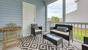 A covered porch with wicker furniture, a metal table, and a patterned rug. - Screened Patio: Townhome 3 Mi to Dtwn Wilson! (Wilson)