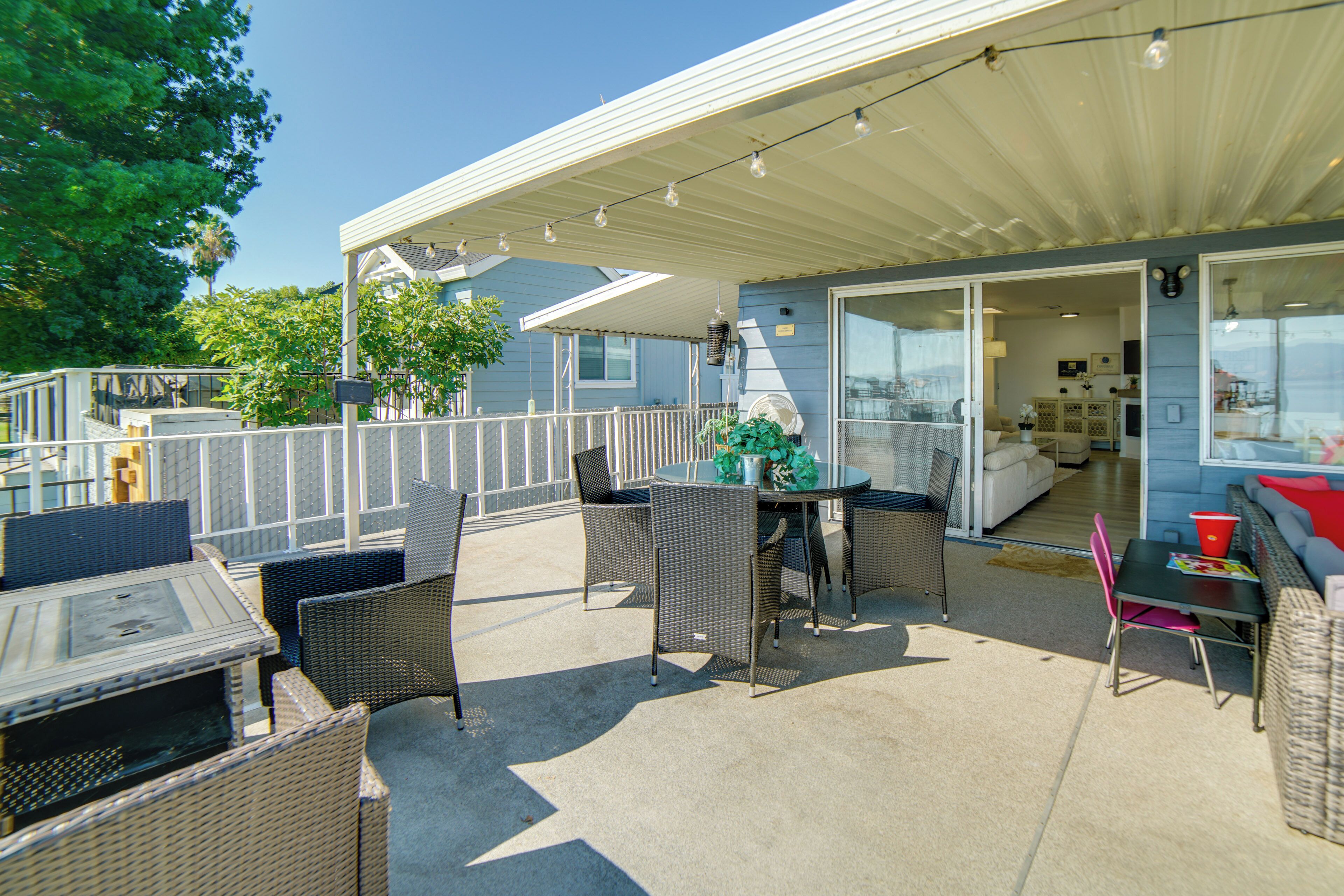 An outdoor patio with wicker furniture, a table, and chairs.