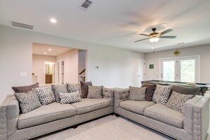 A modern living room with a sectional sofa, a pool table, and a ceiling fan. - Cozy Blue Ridge Cabin: Game Room & Mountain Views (Blairsville)