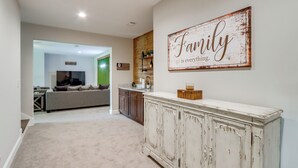 Un salón amplio con un armario blanco grande, un sofá y un cartel en la pared que dice "La familia es lo más importante".