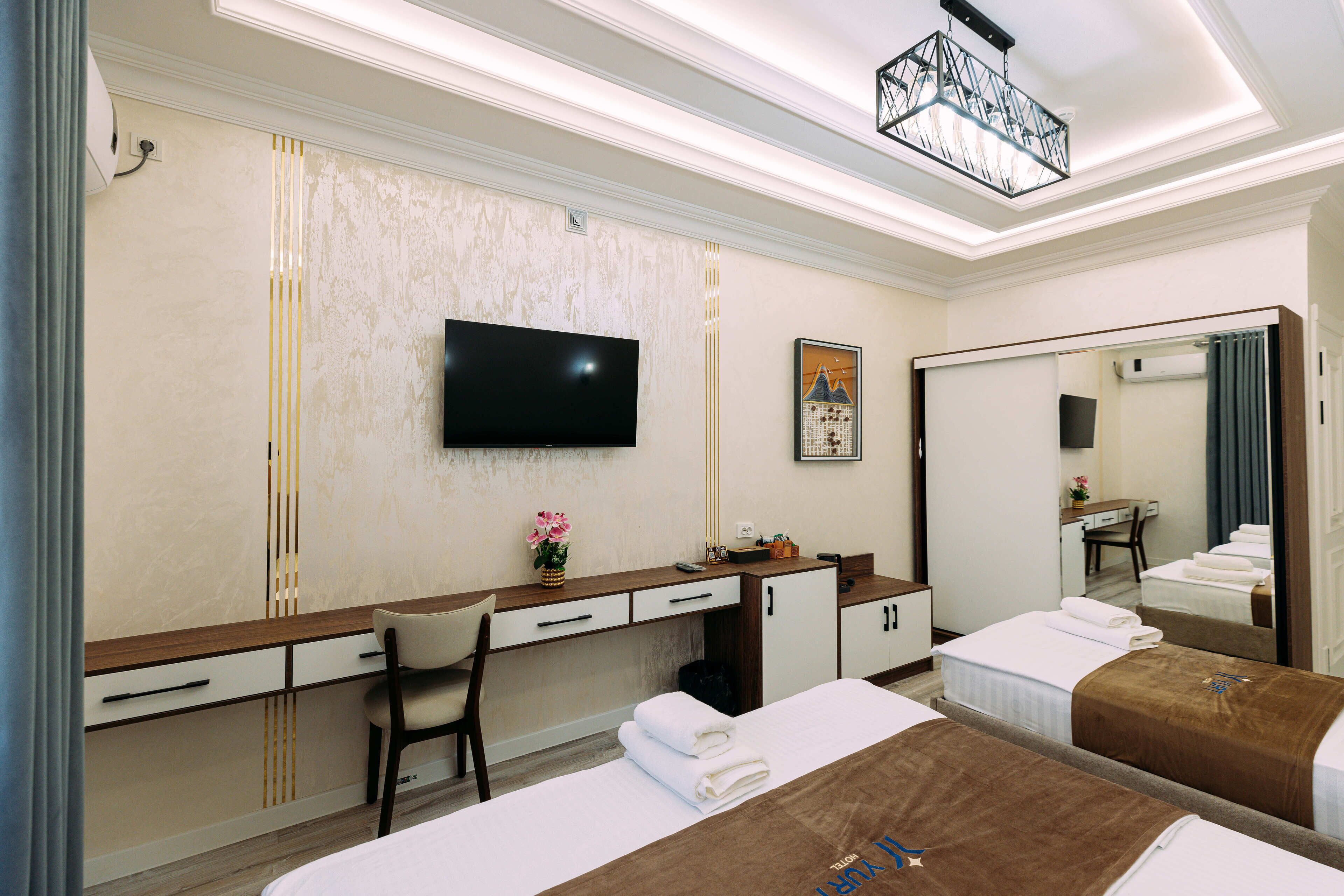 Une chambre d’hôtel avec un grand lit, un bureau avec une chaise, une télévision et un miroir.