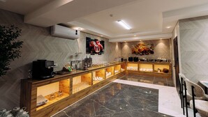 Eine moderne Hotelhalle mit Marmorboden, einem Holzbüro und einer Kaffeemaschine.