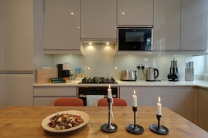 Una cucina moderna con un tavolo da pranzo, candele e un piatto di cibo.