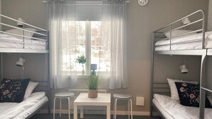 A dormitory room with bunk beds, a small table, two chairs, a potted plant, and a window with curtains. - 6 Person Holiday Park Home in 82011 (Vallsta)