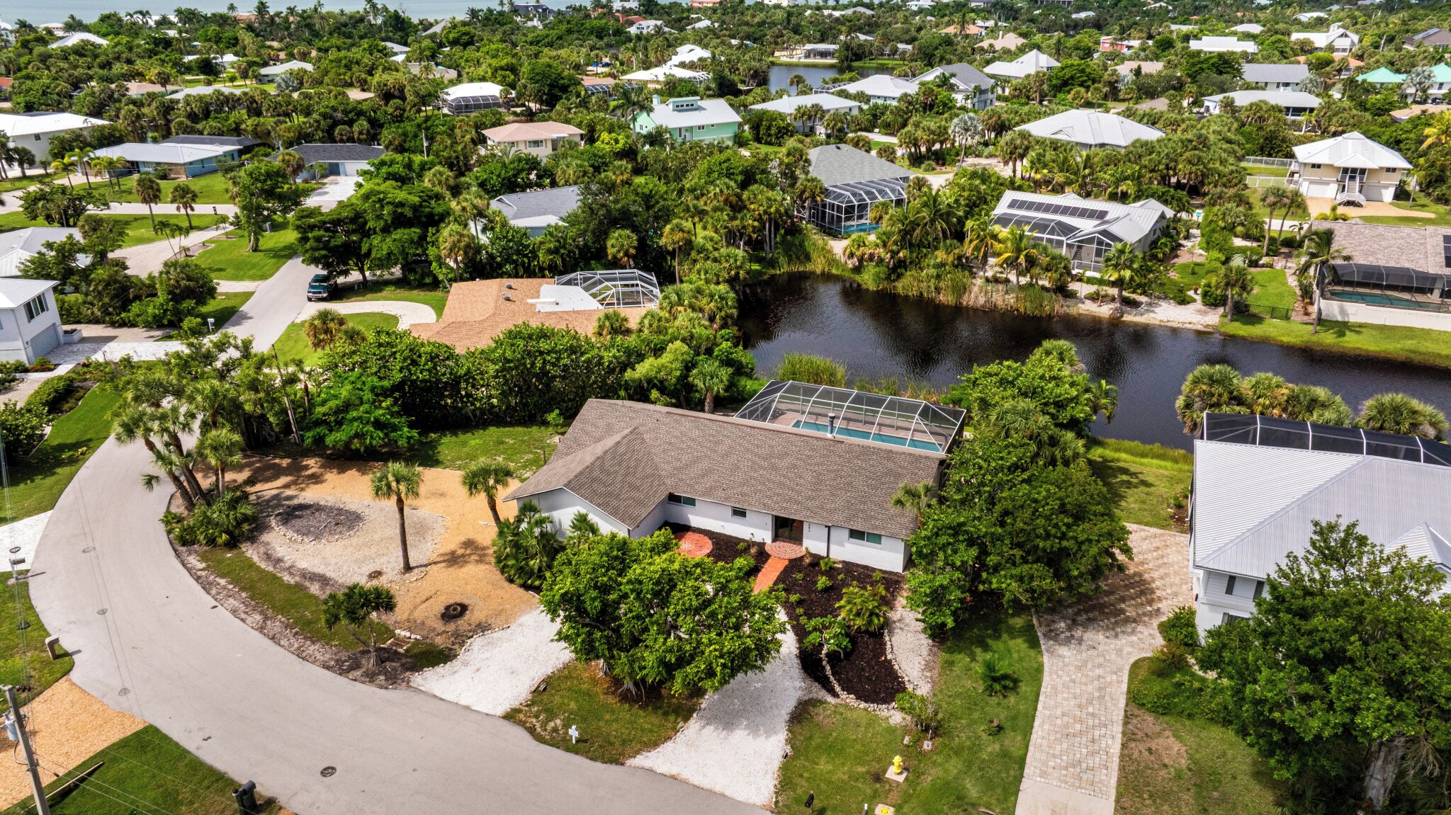 A residential area with houses, a pond, and a curved driveway.