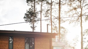 Una casa de madera con fachada roja, una valla de madera y cielo despejado.