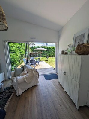 Un soggiorno moderno con un'ampia porta scorrevole in vetro che dà su un patio esterno.