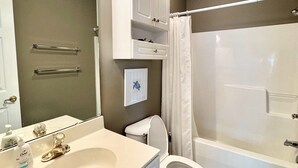 A bathroom with a sink, toilet, and bathtub. - Pet Friendly 2BR Condo, Spacious w/ Vaulted Ceilings! (Little River)