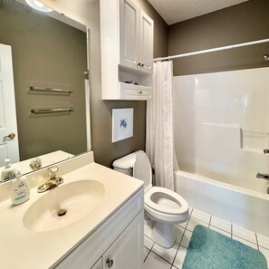 A bathroom with a sink, toilet, and bathtub. - Pet Friendly 2BR Condo, Spacious w/ Vaulted Ceilings! (Little River)