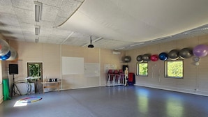Een ruime kamer met een whiteboard, oefenballen en een skeletmodel.