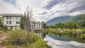 Moderni rakennus, jossa on useita ikkunoita ja joka heijastuu tyynen järven pintaan.